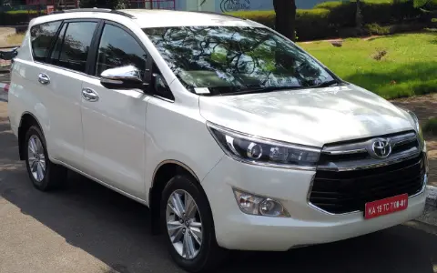 White seven-seater SUV parked on a road