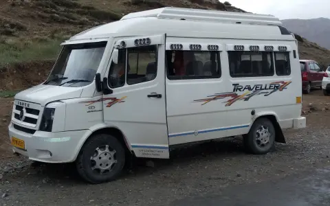 White passenger van parked beside a mountain highway