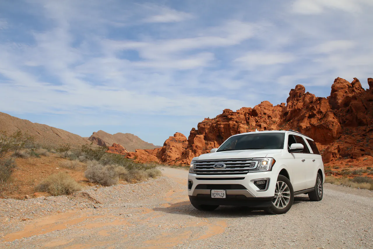 White SUV parked on a scenic desert road